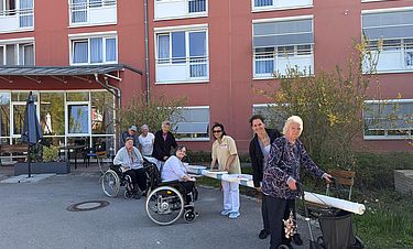 Bewohnerinnen, Bewohner und Mitarbeitende mit dem „gestohlenen“ Maibaum. 