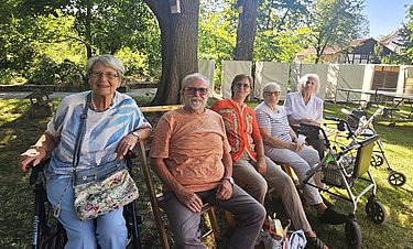 In der Pause der Opernaufführung: Die Betreuungskräfte Torsten Nolte (Zweiter von links), Eva Nolte (Mitte) und die Kursana-Bewohnerinnen entspannen beim Picknick im Edelhofpark.