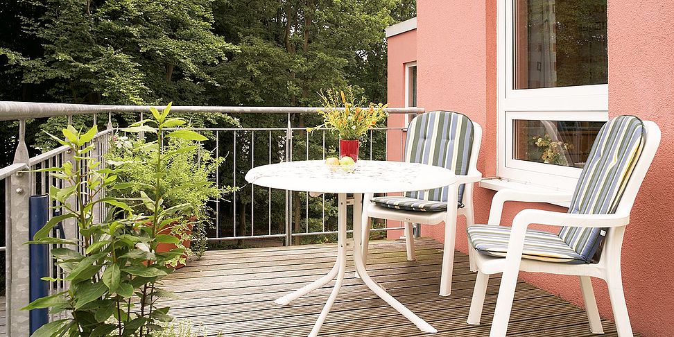 Auf dem Balkon des betreuten Wohnens im Pflegeheim Bremen genießt man Kaffee und Kuchen.