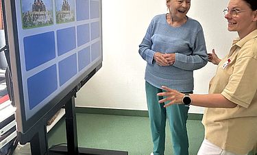 Mitarbeiterin Nadja Rotärmel half der Bewohnerin Isolde Müller dabei, den Aktivitätentisch zu entdecken.