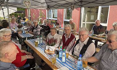 Die Bewohnerinnen und Bewohner genießen das Oktoberfest.