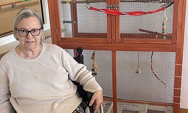 Sonja Maurer beobachtet im Kursana Domizil gern das neue Wellensittich-Paar Sandro und Luna. Sie hat auch das Schild an der Voliere gestaltet.